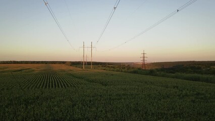 Wall Mural - Electricity pylons. Moving between row of pylons. electric high voltage pylon against sunset sky. Aerial wide footage