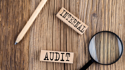 Poster - INTERNAL AUDIT words on wooden building blocks on the wooden background
