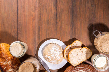 Healthy lifestyle, gluten free fermenting diet. Homemade sourdough. Active bubbly rye, wheat, oat sourdough with different flour and fermentation methods, in glass jars, with raw dough and baked bread