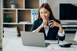 © Kritdanai - Beautiful Asian businesswoman smiling and working happily on her desk in the office.
