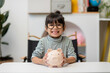 © FAMILY STOCK - Cute asian child girl putting money into piggy bank to save money for the future