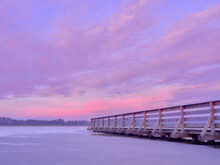Pier On A Frozen Lake. Sunset Over A Frozen Lake.