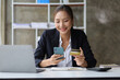 © Wasan - Woman holding credit card using laptop and mobile phone, Online shopping concept.