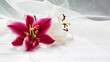 Close-up of white and pink lilies on white wooden table with tulle fabric on the background