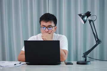 technology, remote job and lifestyle concept - happy asian man  man in glasses with laptop computer working at home office or online shopping, home work, freelance, online learning, studying.