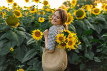 Beautiful Young Woman With Sunflowers Enjoying Nature And Laughing On Summer Sunflower Field.