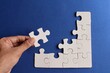 © izzuan - Top view image of incomplete jigsaw puzzle on blue background.