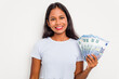 © Asier - Young indian woman holding a banknotes isolated on white background happy, smiling and cheerful.