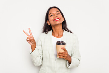 Wall Mural - Young business Indian woman holding takeaway coffee isolated on white background joyful and carefree showing a peace symbol with fingers.