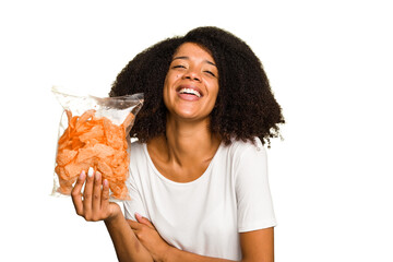 Young African american man holding crips isolated laughing and having fun.