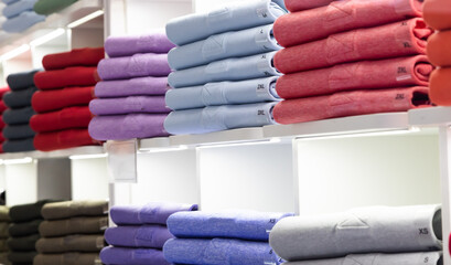 Polo t-shirt store interior. Shop shelves with  colored fashion cotton shirt