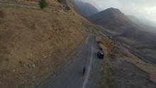FPV Sports Drone Top Shot Man Riding Road Speed Bike On Serpentine Highway Hilly Terrain At Mountain Alpine Scenery. Aerial Top View Sportsman Fast Ride Cycling Movement At Picturesque Rocky Valley 4k