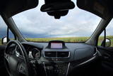 Fototapeta  - Kokpit samochodu osobowego, suwa, z widokiem na pole.