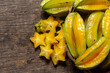 organic carambola asian fruit, star fruit, grown on organic farm in a wicker basket on a rustic wooden table top view with space for writing