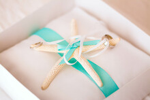 Ring Box With Wedding Rings And Starfish  Attached With White And Turquoise Ribbons