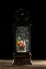 christmas decoration , christmas lantern with santa claus and snow on a wooden table