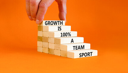 Growth symbol. Concept words Growth is 100 percent a team sport on wooden blocks on a beautiful orange table orange background. Businessman hand. Business motivational growth is a team sport concept.