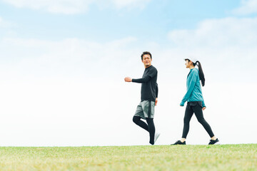 Poster - 青空の見える公園を健康のためウォーキングしてダイエットしている男女
