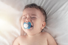 Unhappy Upset Crying Baby Toddler Infant Toddler With Pacifier In Mouth Sitting Lying In Baby Crib.dissatisfied Child Crying Ou Nervous Angry Making Whims Air And Graces.sunshine Sunny Rays Morning