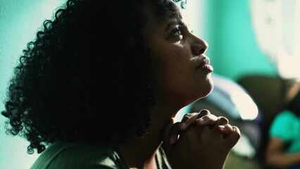 Wall Mural - African American woman praying to God. A spiritual black hispanic girl in prayer having HOPE and FAITH