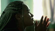 Faithful African American young woman praying to God. Hopeful South american latina Brazilian adult girl in prayer at home