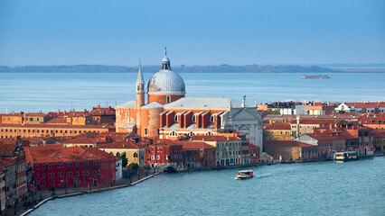 Wall Mural - Aerial view of Church of Santissimo Redentore, or Holy Redeemer. Bird view of Giudecca Canal and Venetian Lagoon on a bright day with blue sky. Beautiful Venice, Italy, Europe.