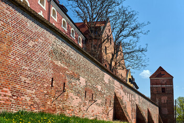 Canvas Print - a historic defensive wall with a brick tower in the city of Torun