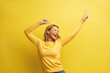 © puhhha - Excited Woman Rejoicing Isolated. Portrait of Overjoyed Girl Standing with Raised Hands and Shouting Yeah, I'm Winner, Rejoicing Victory, Success. Studio Shot Isolated on Yellow Background