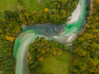 Slovenia - View of the Slovenian river with mountains and autumn colors on the trees from drone view