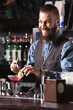 © Dmytro Panchenko - Portrait of a happy bartender making a cocktail.