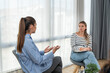 Young woman victim of domestic violence or robbery or mobbing at work talks to an expert psychotherapist for therapy in a comfortable apartment. Psychologist discuss mental problems trauma after shock