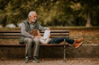 © BGStock72 - Grandfather spending time with his granddaughter on bench in park on autumn day