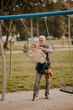 © BGStock72 - Grandfather spending time with his granddaughter in park playground on autumn day