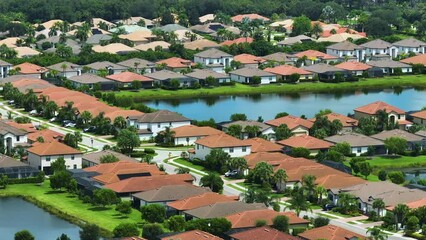 Wall Mural - Aerial view of tightly packed homes in Florida closed living clubs with lake water in the middle. Family houses as example of real estate development in american suburbs