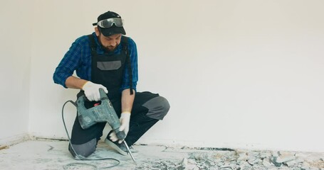 Poster - Tiles to be removed with an electric percussion demolition hammer by a craftsman in work clothes, in a renovated apartment.