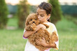 © Angelov - a little girl playing with her maltipoo dog a maltese-poodle breed