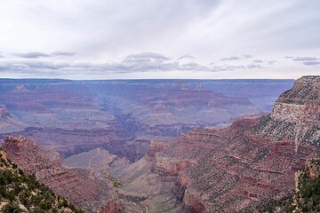 Canvas Print - Aerial shot of the Grand Canyon in Arizona with beautiful rock formations under a cloudy sky