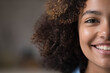 Closeup cropped front half face view of beautiful African teenage girl having natural afro curly hairs and charming wide toothy smile looks at camera. Advertises dental clinic services, gen Z person
