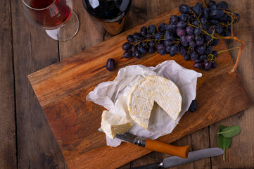 Wall Mural -  Aufgeschnittener Camembert Käse mit Trauben und Weinglas