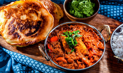 Wall Mural - Butter chicken with rice and naan bread served in karahi pots