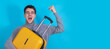 © carballo - young man celebrating excited with suitcase isolated on background