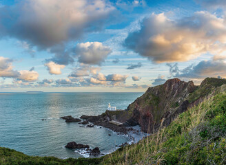 Wall Mural - Lovely sunrise landscape image of Devon coastline in England with stunning golden hour light on the land and sky