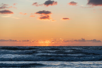 Wall Mural - Stunning Summer sunset landscape image of Widemouth Bay in Devon England with golden hour light on beach