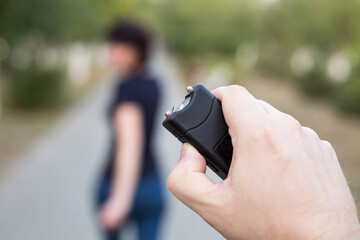 A man with a stun gun chases a woman to rob.