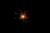 Fototapeta Sypialnia - One burning sparkler stick on black background