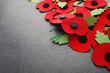 World War remembrance day. Red paper poppies on dark stone background