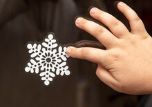Paper Snowflakes Are Glued By Hand On The Glass Of The Window.