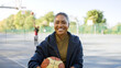Portrait of attractive young female holding a basketball and smiling to camera 