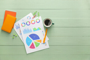 Poster - Business charts, cup of coffee and stationery on green wooden background