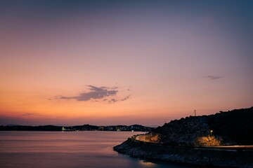 Wall Mural - Sunset in Vouliagmeni Athens Greece. Seaside road with trail lights from the moving cars.